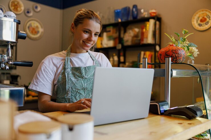 A skilled barista works on a laptop in a cozy coffee shop on a lovely afternoon