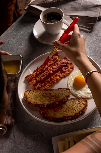 숙련된 푸드 메이크업 아티스트가 전문적인 손으로 시각적으로 놀라운 아침 식사 접시에 최종 손질을 추가합니다.