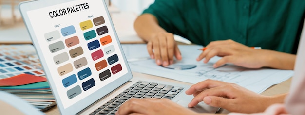 skilled interior designer using architectural equipment draw a blueprint while interior designer select appropriate color carefully by using laptop creative design and teamwork concept variegated