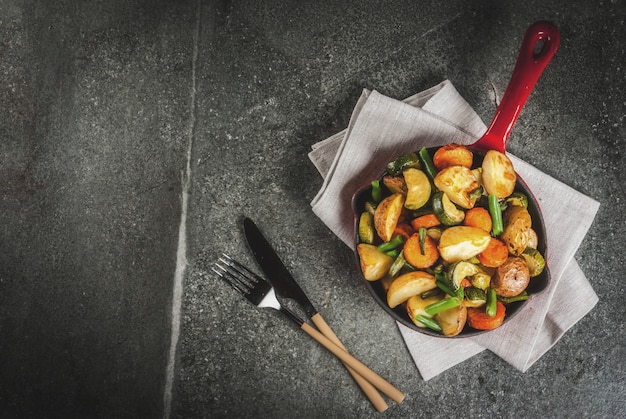 Skillet with  fried seasonal autumn vegetables (zucchini, potatoes, carrots, beans)