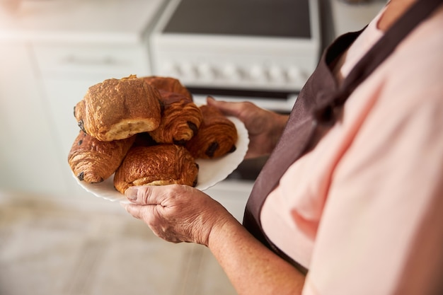 Skillful grandmother having fresh pastries ready for dinner