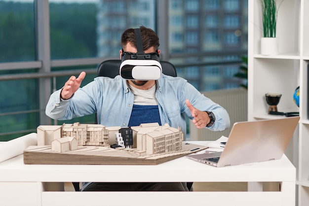 Photo skillful male architect reviewing architectural project with vr goggles at modern office.