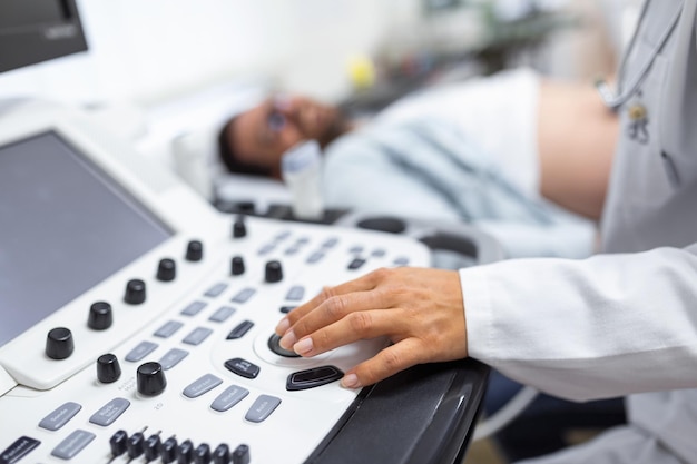 Skillful sonographer using ultrasound machine at work Man visiting his doctor for ultrasound examination Professional doctor sonographer performing ultrasound in modern clinic