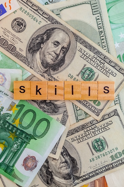 Skills inscription on wooden cubes on the texture of us dollars and euro banknotes