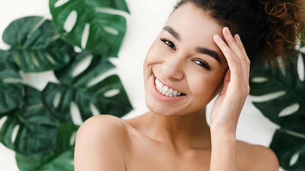 Skin care. African-american woman over background with tropical leaves