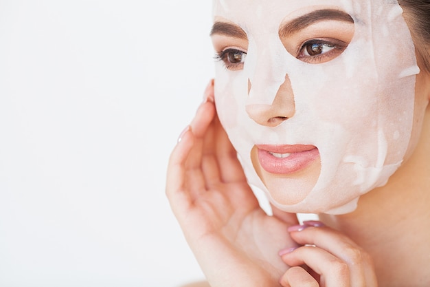 Skin Care. Beautiful Girl With Sheet Mask on Her Face