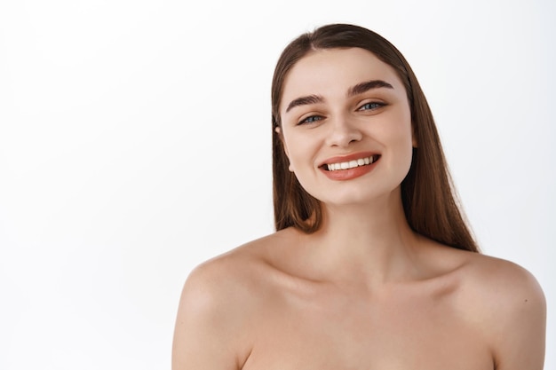 Cura e bellezza della pelle. ritratto di donna del primo piano con pelle del viso naturale sana, denti bianchi perfetti, sorriso felice brillante, concetto di cura della pelle e spa, sfondo bianco