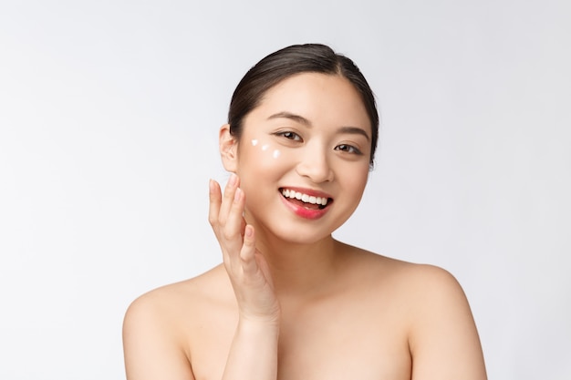 Photo skin care beauty woman beauty woman smiling applying cream beauty portrait of beautiful asian caucasian female model isolated on