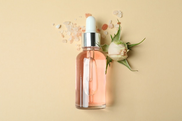 Skin care concept with essential rose oil on beige