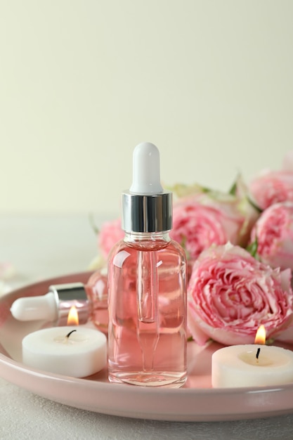 Skin care concept with essential rose oil on white textured table