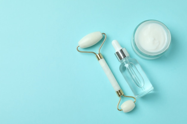 Skin care concept with face roller on blue background