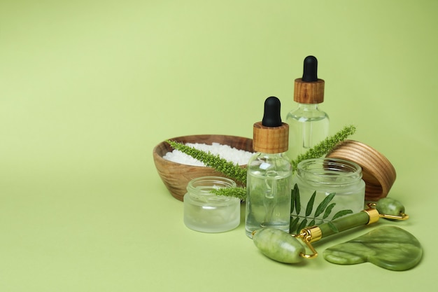 Skin care concept with face roller on green background