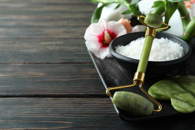 Skin care concept with face roller on wooden table