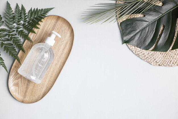 skin care concept with white bottle and palm leaves on tropical background