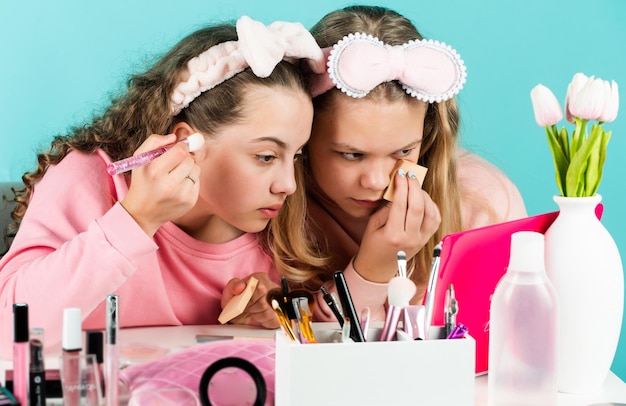 Skin care cosmetics for children beauty and fashion two happy girls at hairdresser friendship and sisterhood family bonding time childhood happiness retro kids put on makeup Confident beauty