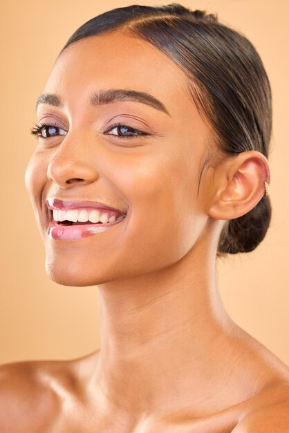 Skin care face and smile of woman in studio for glow cosmetics dermatology or makeup aesthetic female happy about self love natural skincare and spa facial shine results on a brown background