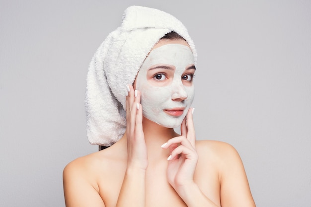 Skin care mask. Beautiful girl against white background getting beauty tretment. Spa concept with copy space