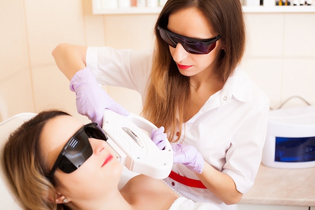 Skin care. Woman receiving laser epilation treatment on her face