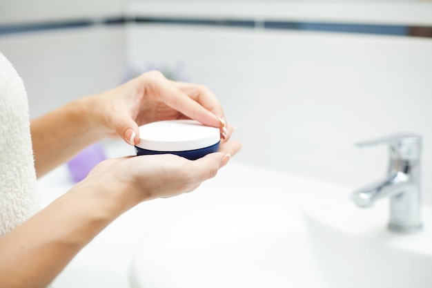 Skin care. Woman use skin care products at home in light bathroom.