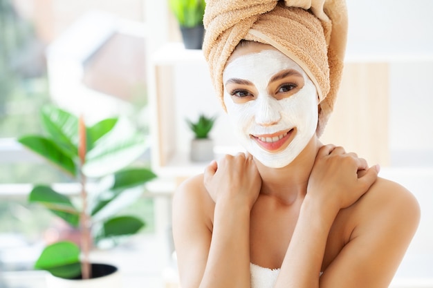 Foto cura della pelle, donna con una bella pelle del viso che applica la maschera sul viso.