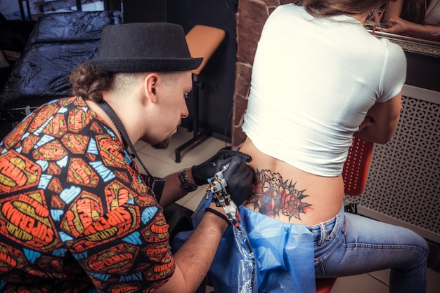 Skin master demonstrates process of making a tattoo