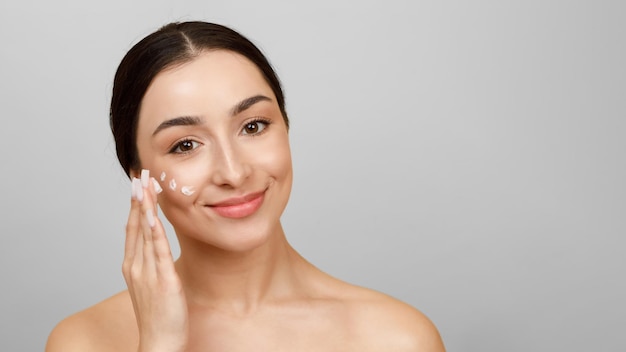 Skin Nourishing Concept Beautiful Indian Woman Applying Face Cream