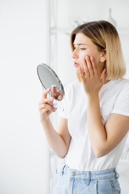 Problema della pelle trattamento dell'acne donna toccando il viso