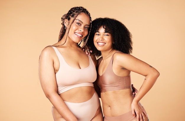 skincare beauty and black women friends in underwear in studio isolated on a brown background empowerment portrait lingerie and body positive happy girls with makeup cosmetics and healthy skin