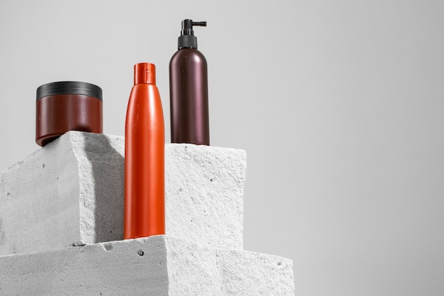 灰色のコンクリートブロックのスキンケア化粧品瓶