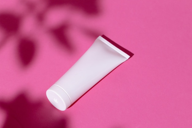 Skincare products containers on bright pink background