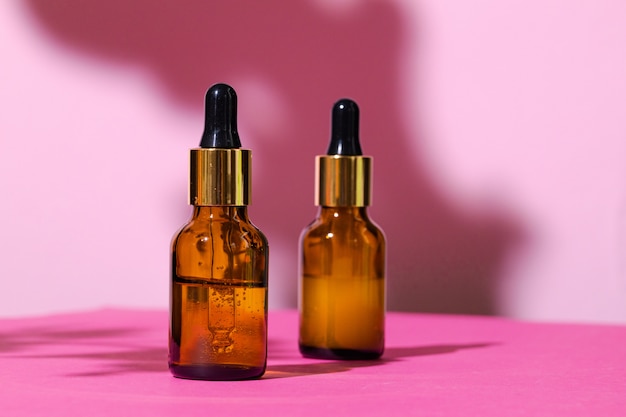 Skincare products containers on bright pink table