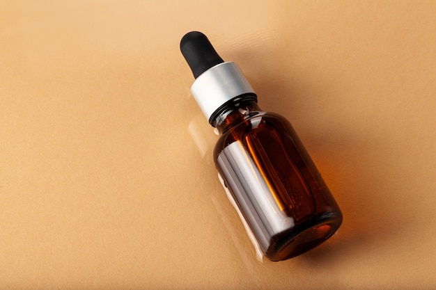 Skincare serum bottle on a light beige background close up