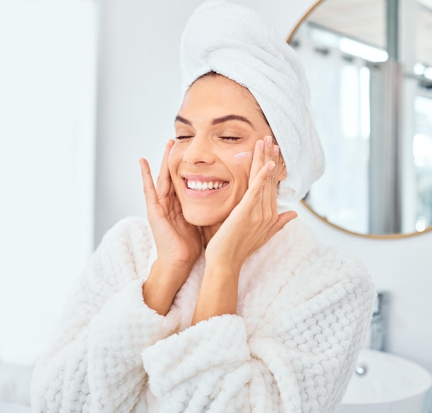 Photo skincare smile and woman with face cream in a bathroom for wellness dermatology and treatment in her home facial lotion and happy female person with sunscreen cosmetic and collagen beauty cream