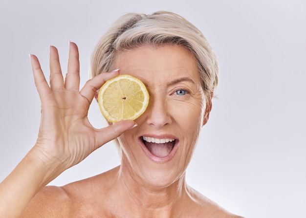 Skincare wellness and face of mature woman with wrinkles holding lemon with nutrition vitamins and health Portrait of happy senior lady with fruit and healthy organic and fresh self care routine