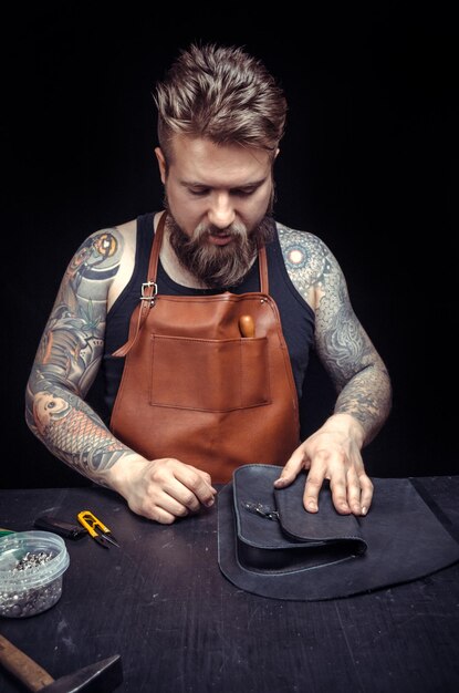 Skinner demostrating leather cutting process in leather shop