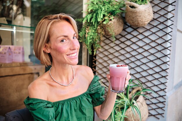 Photo skinny and fitness woman looking at camera with healthy smoothie