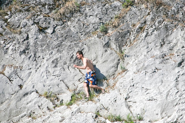 Skinny man runs along the rock