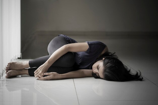 Foto donna magra sdraiata sul pavimento