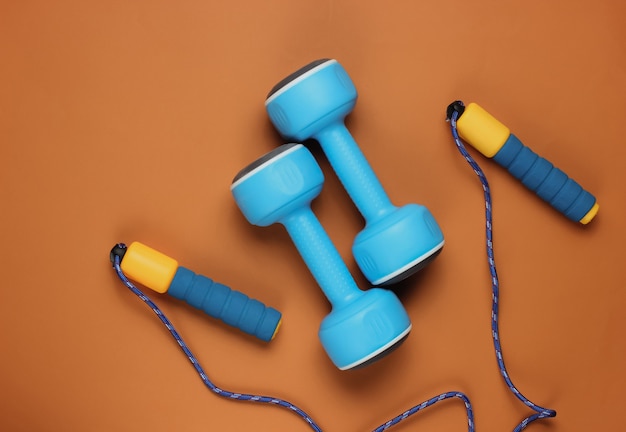 Skipping rope and dumbbells on brown