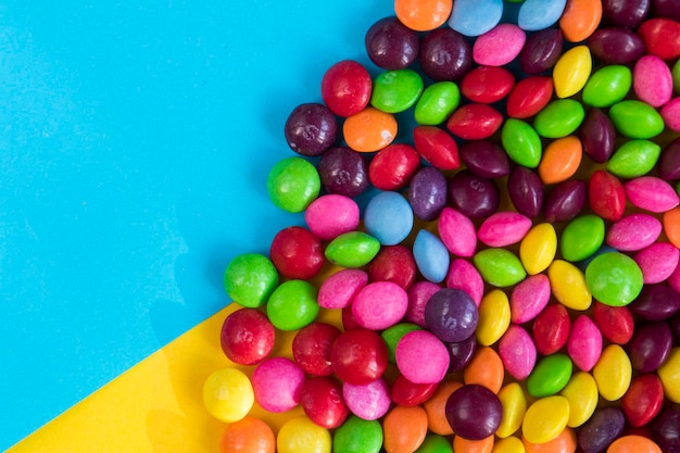 Конфеты Skittles на красочном столе красочные сладкие конфеты