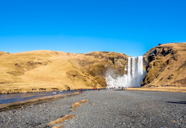 Skogafoss groot watervaloriëntatiepunt in ijsland met regenboogbreking met sneeuw en ijs