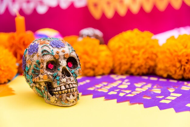 写真 頭蓋骨、刻まれた紫色の紙、祭壇でのケンパスティールの花、死者の日のお祝い