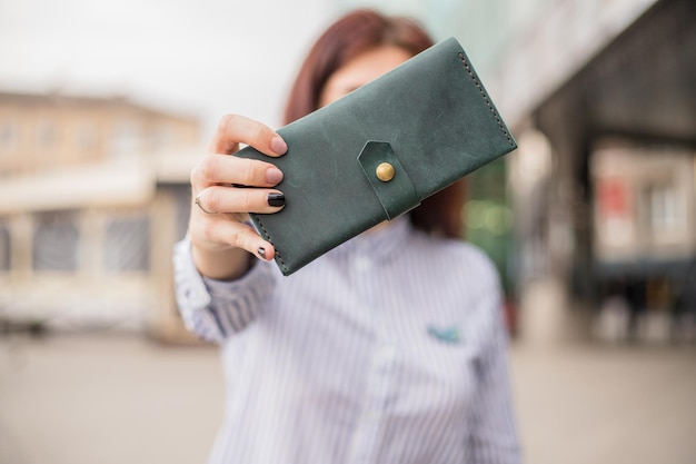 사진 하늘색 핸드백 지갑과 매니큐어가 있는 아름다운 여성의 손