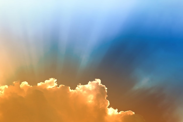 Небесно-голубой и оранжевый свет солнца сквозь облака в небе выживают.