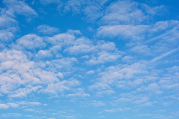 Небесно-голубое небо на фоне белых облаков Кудрявые облака в солнечный летний день Легкая облачность Хорошая погода Простое фоновое небо для летнего плаката Летний макет Мягкий фокус