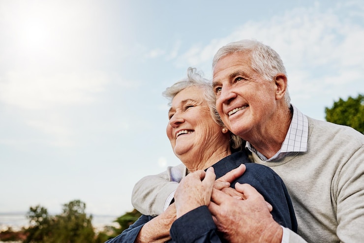 Photo sky elderly couple and hug outdoors or happy in retirement or husband and wife in nature mature man and woman smile in vacation or senior citizens care and embrace or date at the park for romance