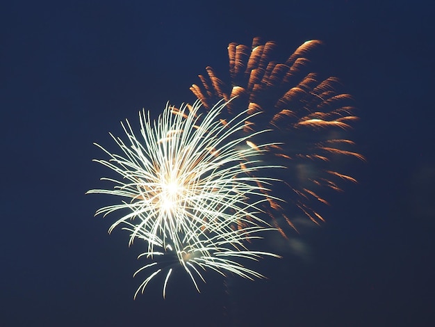 sky illumed with fire crackers against clear blue sky