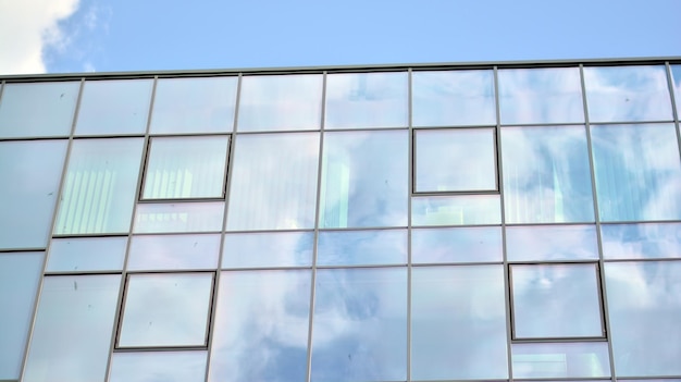 the sky is blue and the clouds are reflected in the windows of this building.