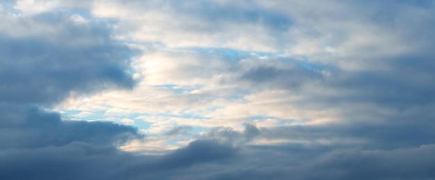 夕日の雲に照らされた濃い青と光の空