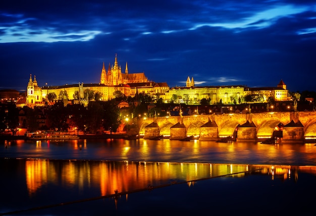 Photo skyline of prague with vitus cathedral and charles bridge at night, czech republic, toned